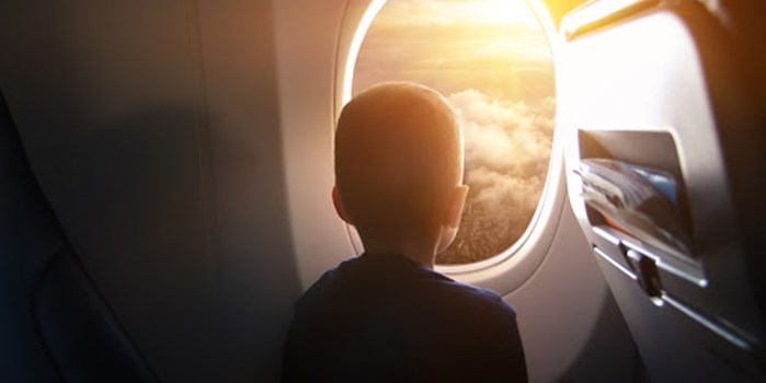  A young boy looking out of a plane window