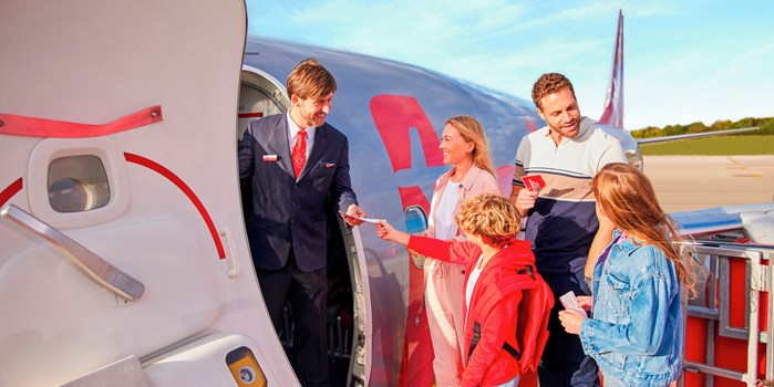 Family being greeted by Jet2 crew by the aircraft